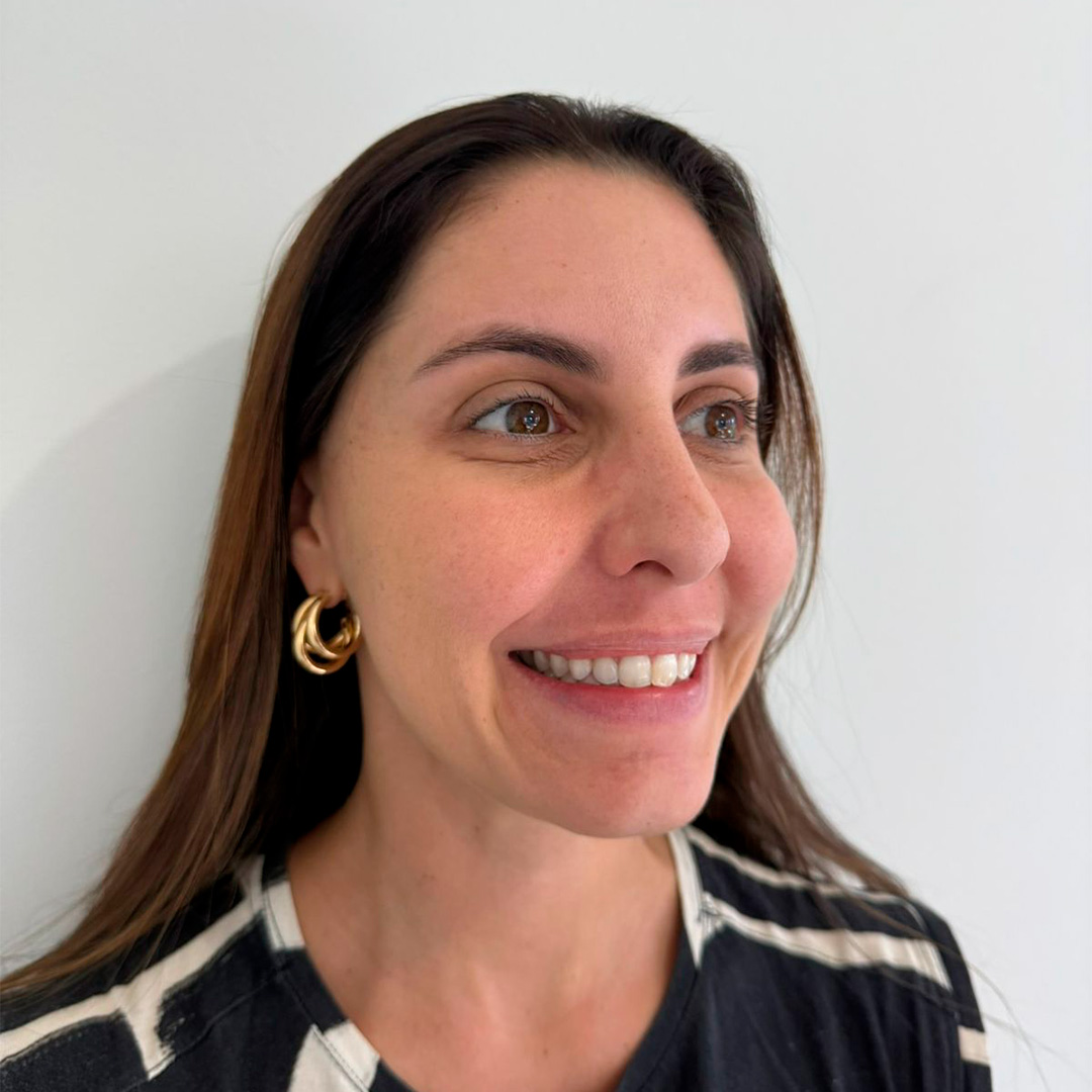 Mulher de perfil mostrando o sorriso depois do procedimento em clinica de estetica