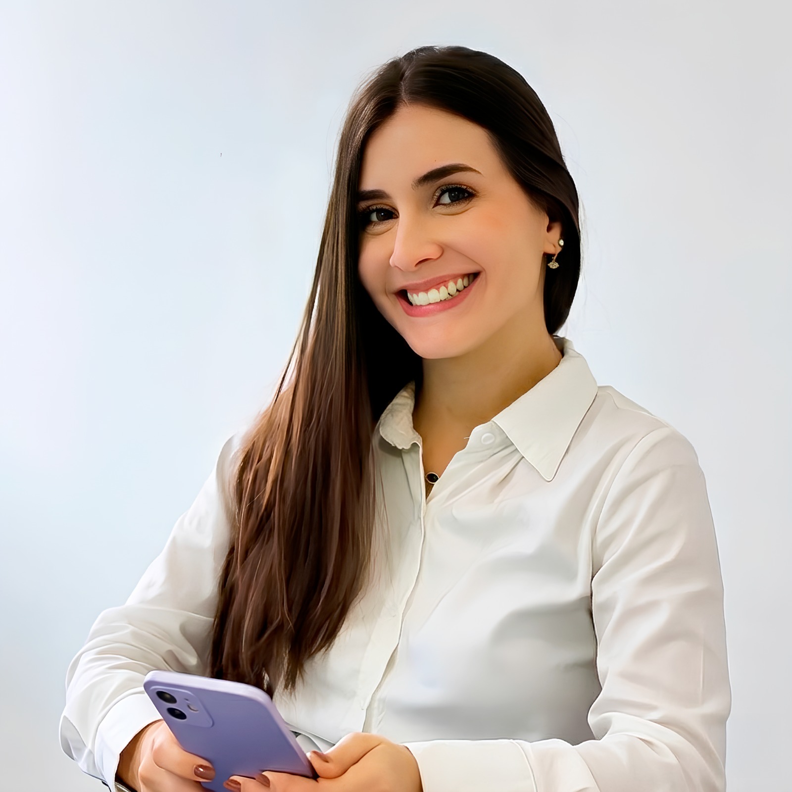 Dra Julya Camargo responsável pela clinica de estetica posando para foto usando um uniforme branco e sorrindo